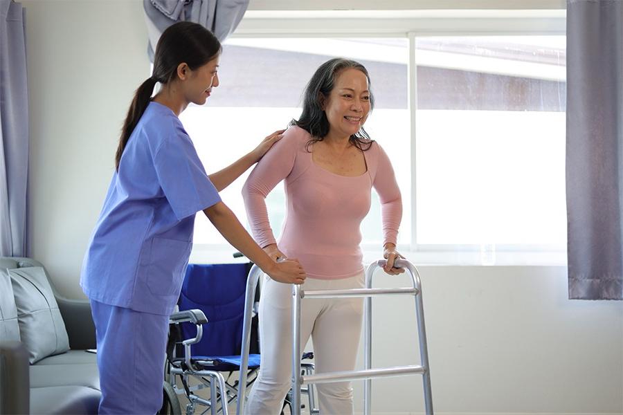 Woman lifting weight with assistance from medical professional